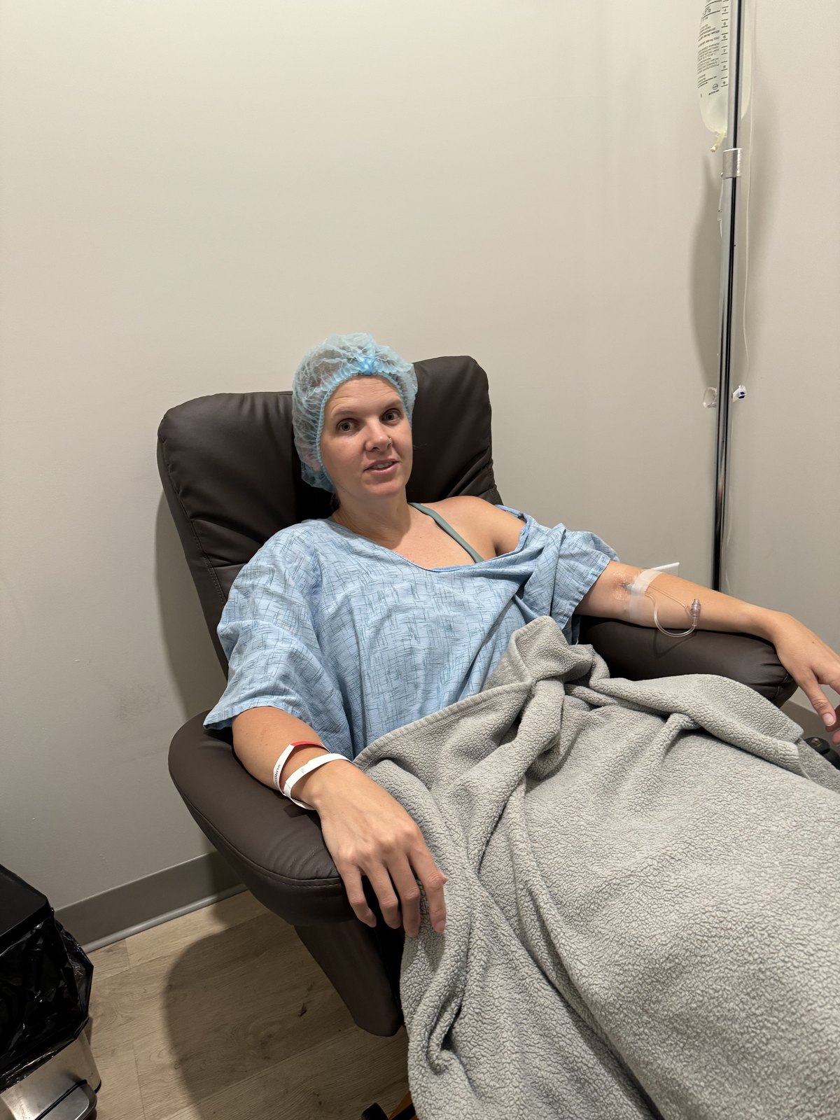 Amy in a medical chair wearing a hair cap before a procedure at Victory